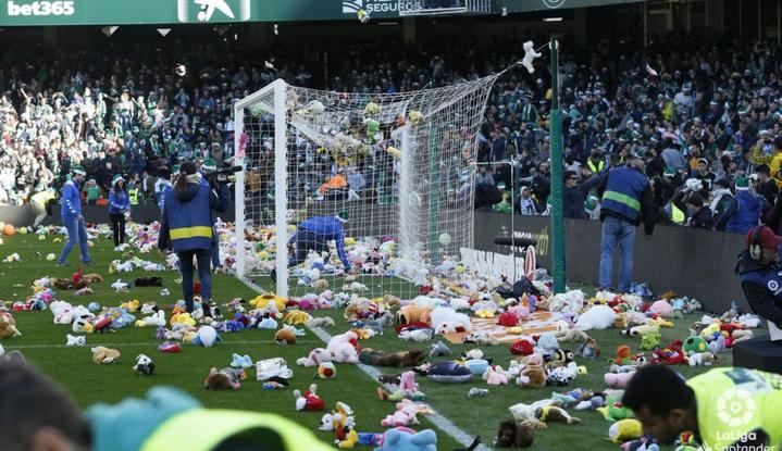 Un bonito detalle en Navidad : los aficionados del Betis tiran miles de peluches al césped para regalárselos a los niños desfavorecidos 