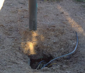 Un cable a la vista en una farola del parque.